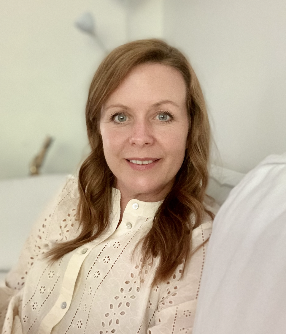 Woman looking at the camera and smiling, head and shoulders photo.